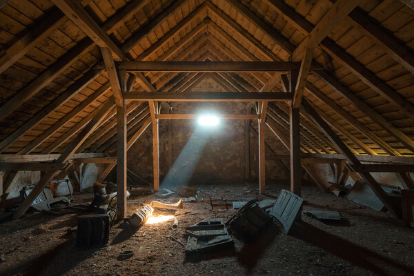 A ray of sunlight shines into a dark dirty attic